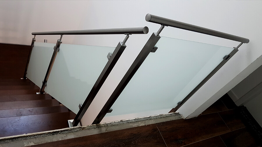 Metalowe schody wewnętrzne do domu z metalową balustradą i szkłem