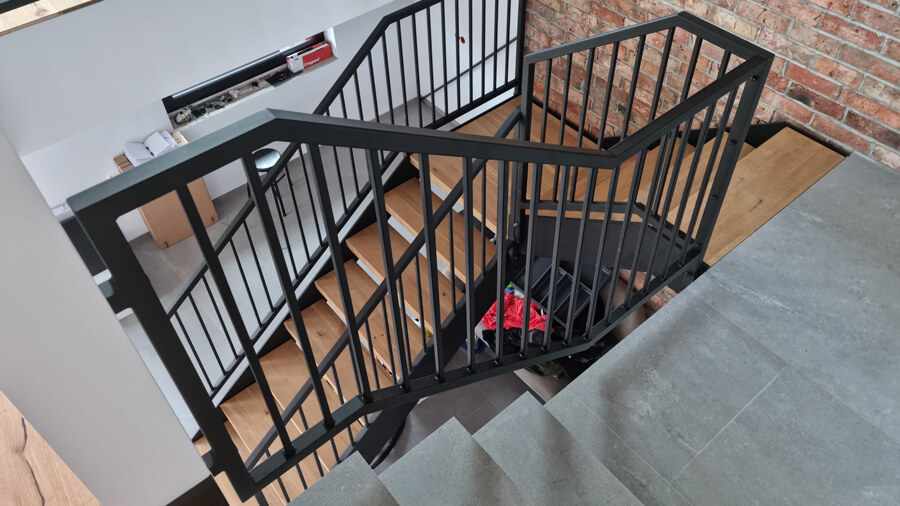 Metalowe schody wewnętrzne do domu z metalową balustradą